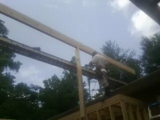 Carpenter setting a ridge beam over a new addition frame — Ice Dam Removal by Roofing Brothers in Cobalt