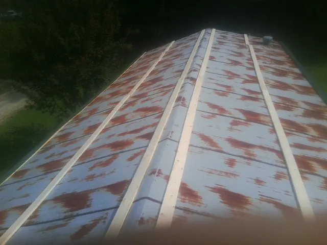 Rusted metal roof panels with new wood purlins before replacement — Storm Damage Roof Repair in Cobalt by Roofing Brothers